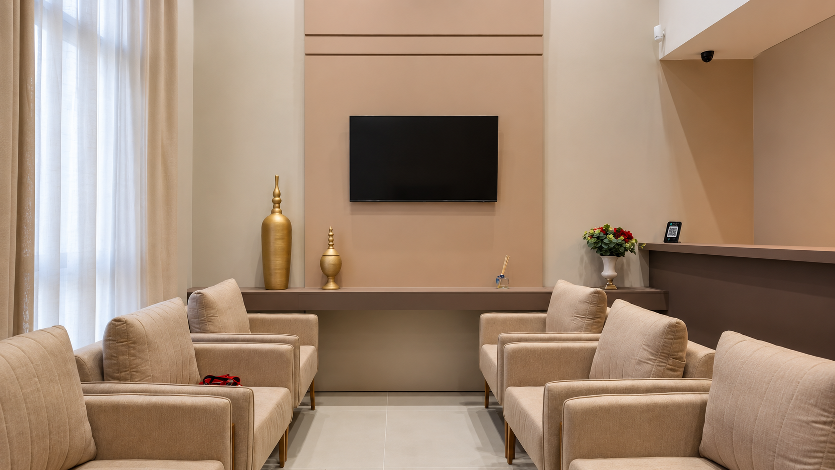 Sala de espera com poltronas confortáveis, TV e decoração em tons neutros